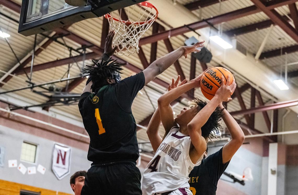 The Natomas Nighthawks’ Manno Jenkins (4) attempts to score against the Monterey Dores’ Suheib Ibrahim (1) during a 2024 CIF Northern California regional Divison IV boys basketball semifinal.