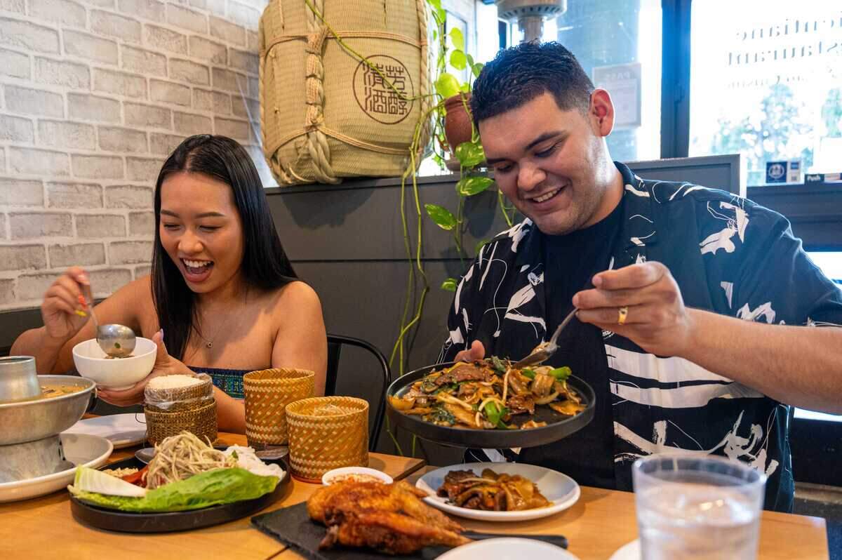 Ellie Andrade, right, scoops tom kha, hot and sour coconut soup, while Lupe Andrade forks beef drunken noodles at Vientiane Restaurant in West Sacramento on July 15.