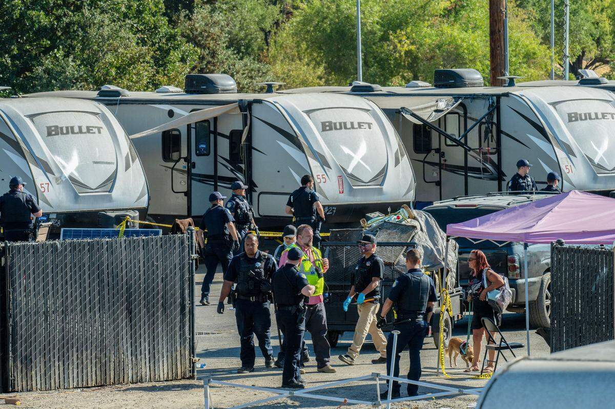 Sacramento police officers and other city workers enter Camp Resolution on Colfax Street to take back the FEMA trailers the state had loaned the city while homeless scrambled to get their belongings on Monday. Residents marked an X on the trailers occupied by disabled people. 