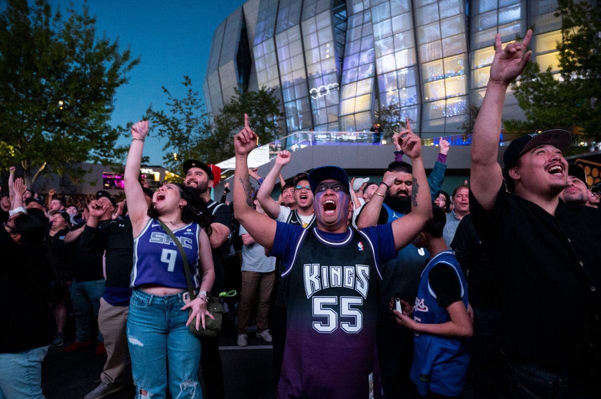 Sacramento Kings fans including Kimberly Del Carmen, left, and Joseph Deleon, center, celebrate in the watch zone in front of Golden 1 Center as the Kings win the first round of the playoffs against the Golden State Warriors on Saturday night.