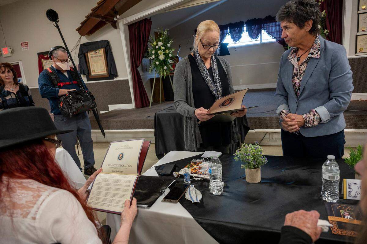 After the memorial for their brother, James Mark Rippee, his sisters Linda Rippee Privatte, center, and Catherine J. Rippee-Hanson, left, look over a memorial resolution for their brother presented to them by Senator Susan Talamantes Eggman, right, who spoke at the service in Vacaville on Friday.