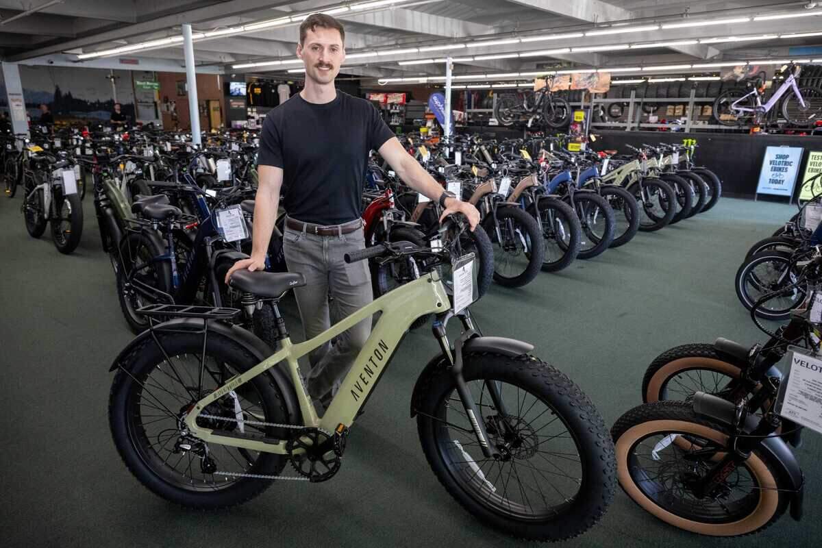 Jacob Stabler stands with an Aventon e-bike at ATV Wholesale Outlet on March 17, 2026, in Old Foothill Farms. Stabler said electric devices account for about 80% of the Auburn Boulevard business's sales as demand for e-bikes continues to grow.