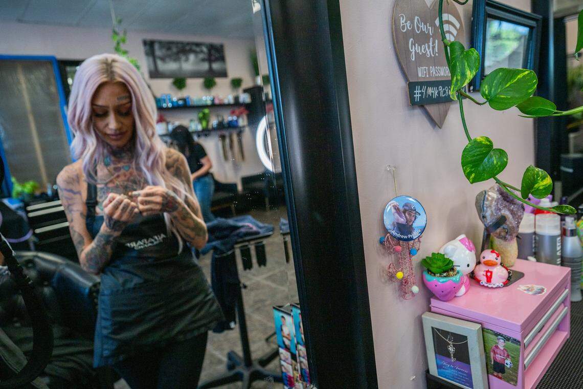 Erika Pringle holds a bracelet engraved with her brother Andrew Pringle’s name that reads “Drew-Boo & Sissy Forever and Always” in July at a salon where she works on  in Sacramento. She says having pictures and mementos nearby helps her focus on the good times with her brother rather than the traumatic memories of his death in the accident.
