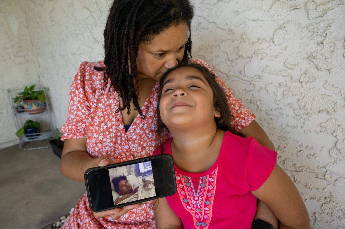 Destinee Campbell shows a photo on her phone to her daughter, Nayelieden, 6, on Aug. 11 in Rio Linda, after she delivered her by C-section in 2016. Campbell said you could see in her face how disoriented she was after the birth. She said she’s preferred her two home births since and hopes to deliver her fourth child at home in February.