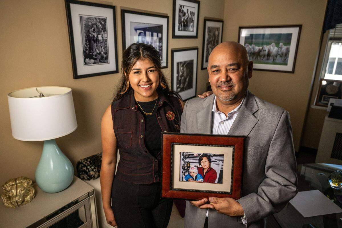 Former Assemblyman Alberto Torrico stands with his daughter Amy-Elizabeth last month, while holding a photo of his mother and son Mateo. His mother is of Japanese descent from Bolivia.