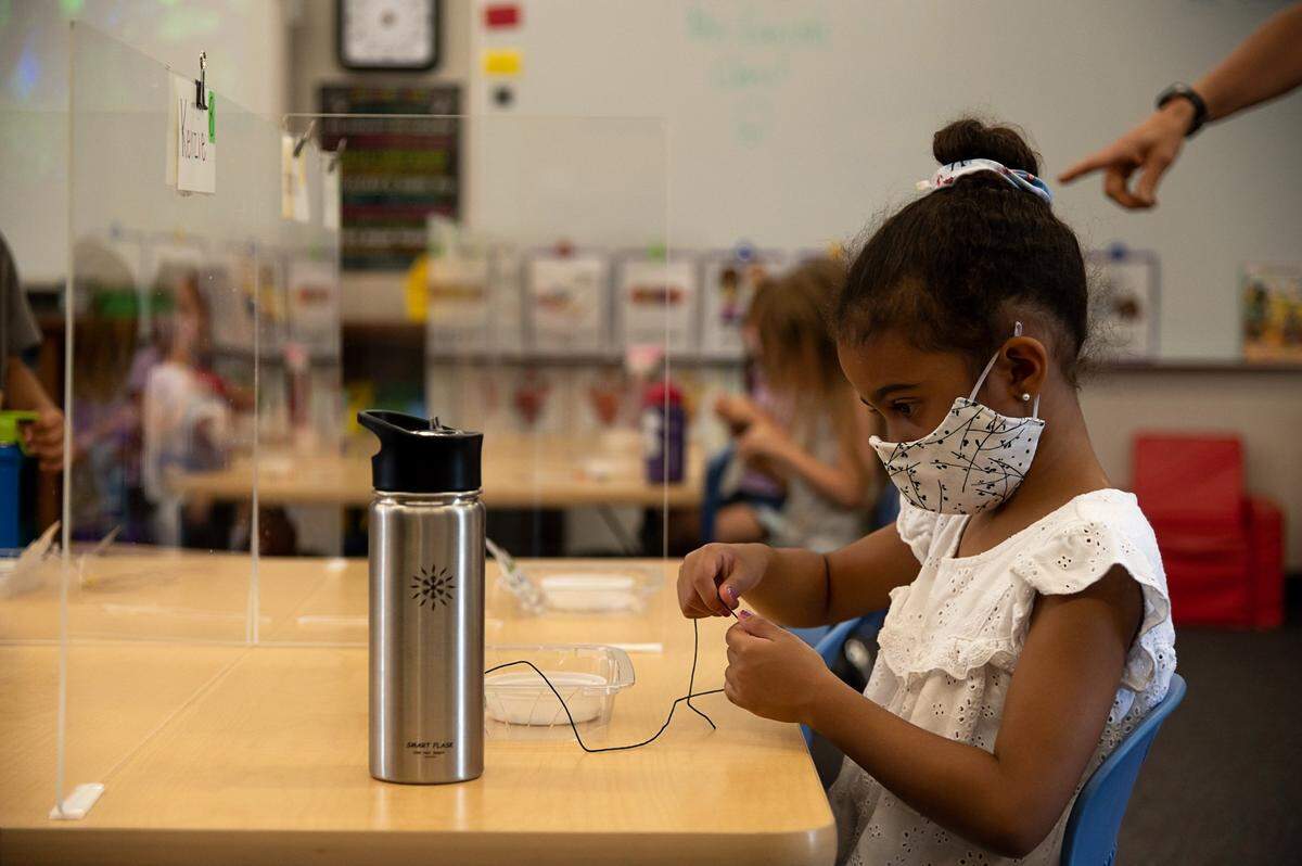Kenzie Burse sits behind plexiglass that separates her from other students during the first day of school at Rescue Elementary School on Monday, Aug. 17, 2020 in Rescue. The school is able to open for in-class instruction because El Dorado County is not on the state’s coronavirus watchlist.
