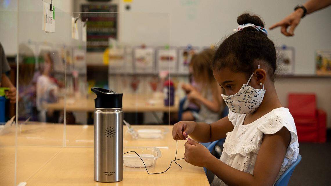 Kenzie Burse sits behind plexiglass that separates her from other students during the first day of school at Rescue Elementary School on Monday, Aug. 17, 2020 in Rescue. The students brought water bottles because the drinking fountains are closed. The school is able to open for in-class instruction because El Dorado County is not on the state’s coronavirus watchlist.