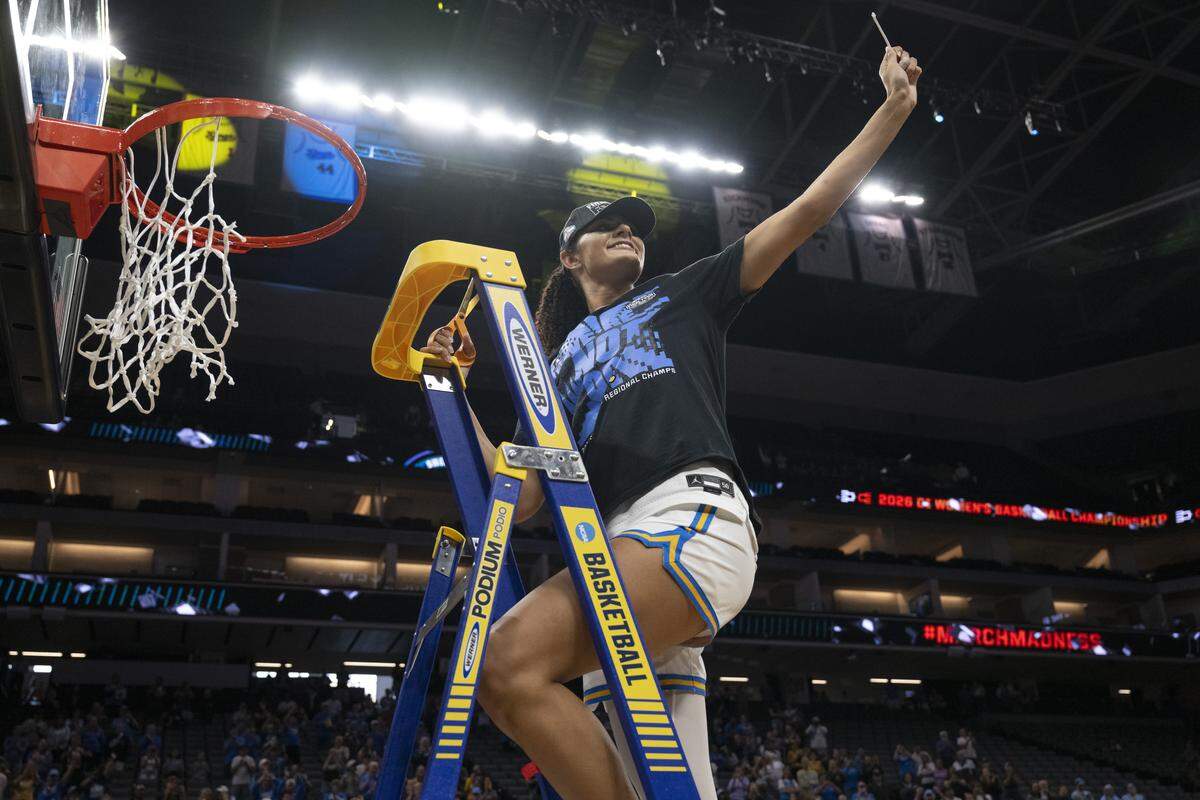 UCLA center Lauren Betts (51) cuts down the net after winning the Sacramento Regional 2 as a part of the March Madness tournament at Golden 1 Center in Sacramento on Sunday, March 29, 2026.