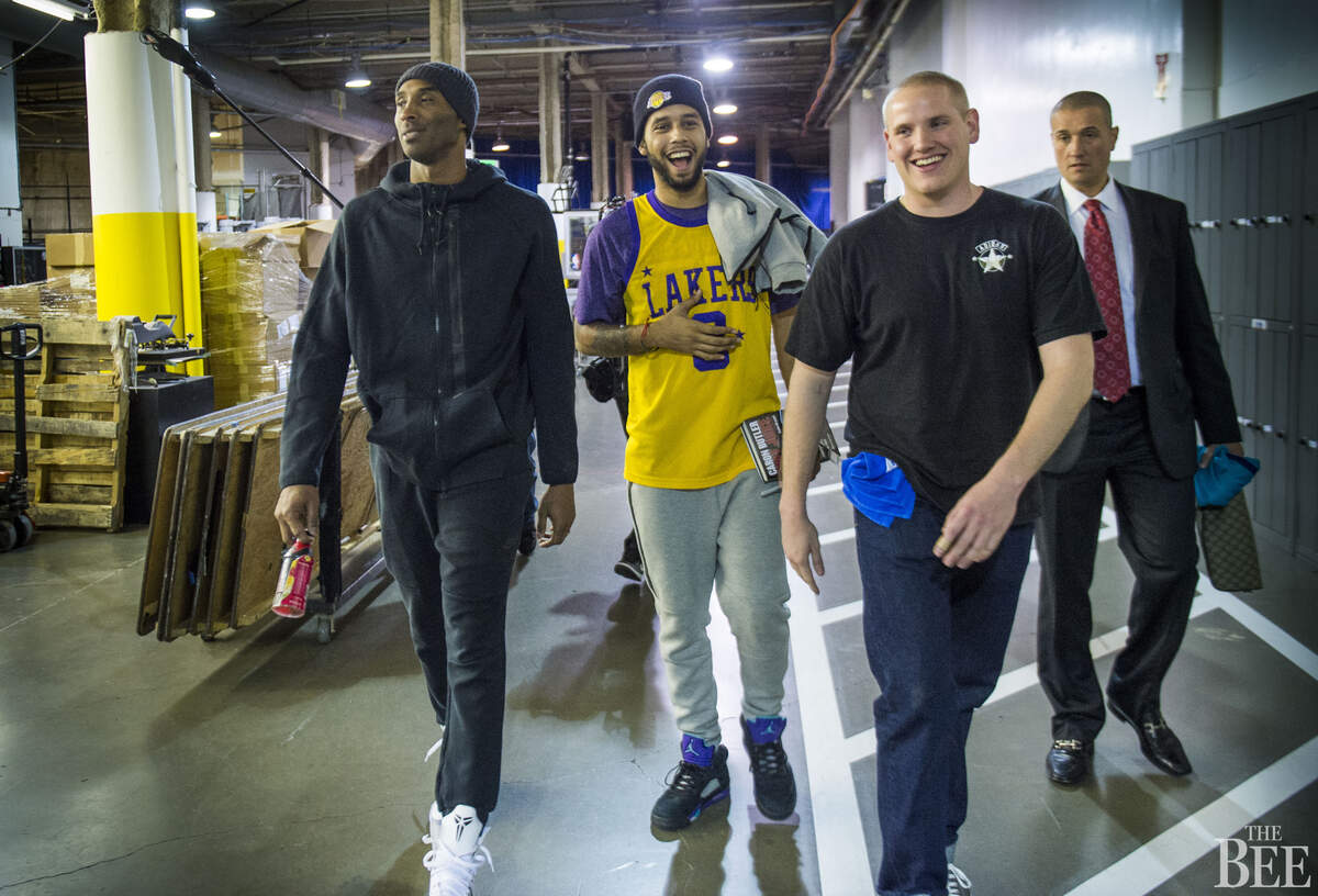 Los Angeles Lakers forward Kobe Bryant (24) walks to a press conference with French train heroes Anthony Sadler and Spencer Stone after Bryant played his last game at Sleep Train Arena.