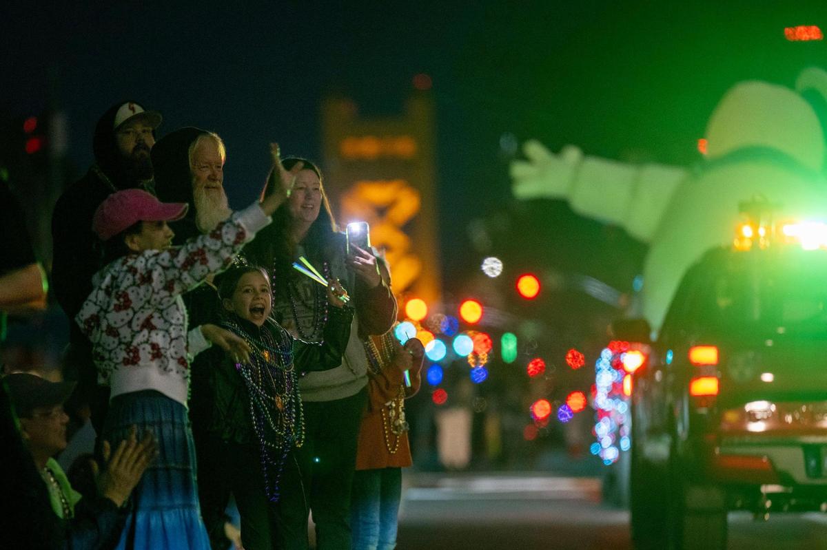 Locals cheer as floats drive by on Capitol Mall at the City of Trees Parade to celebrate Mardi Gras on Saturday.