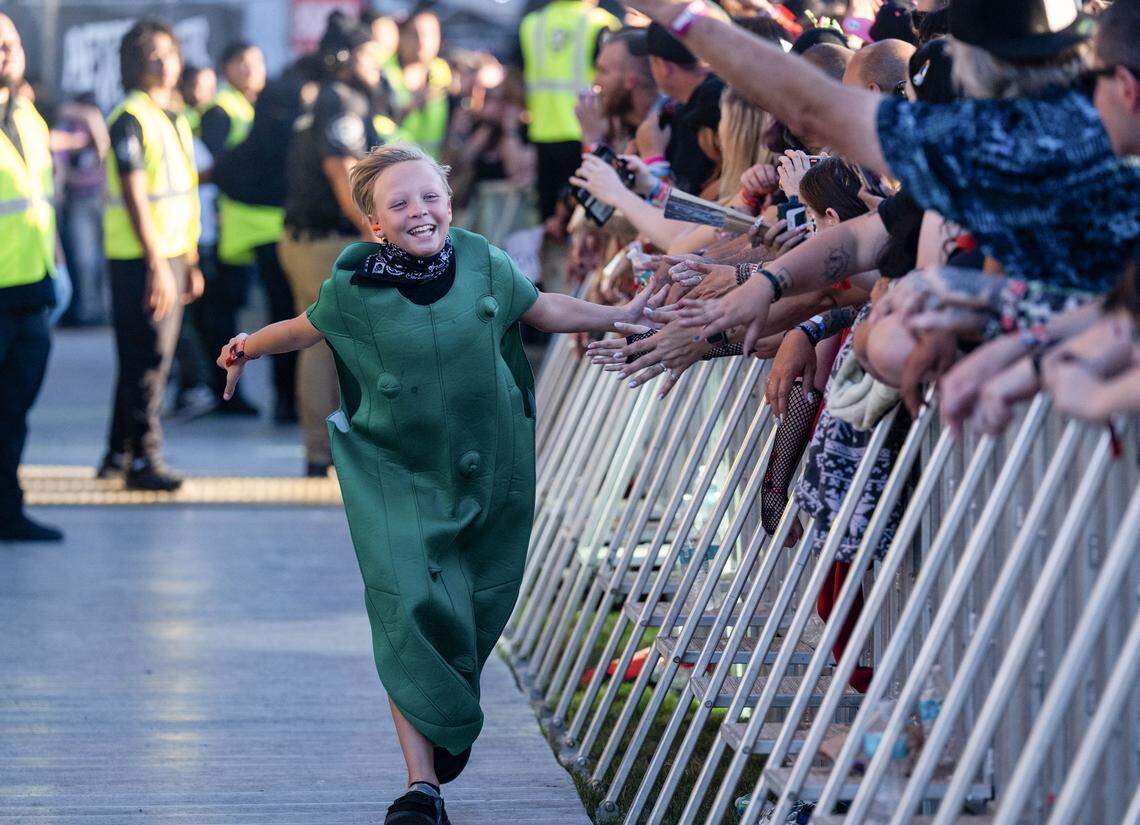 A child in a pickle costume high fives the audience after crowd surfing to the pit during the Aftershock festival on Sunday, Oct. 5, 2025, in Sacramento’s Discovery Park.