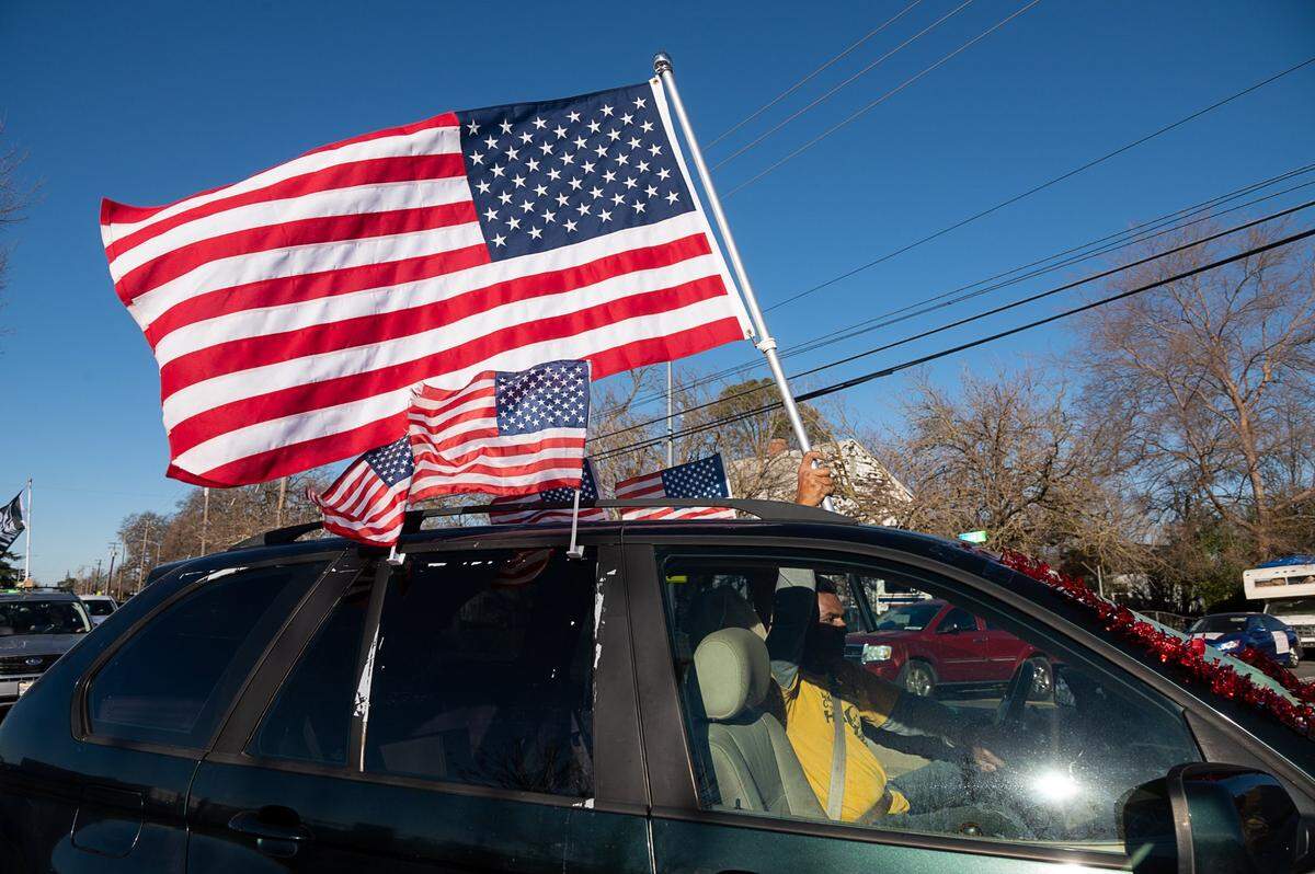 American flags fly on a car that joined the #ReclaimMLK Day car caravan in celebration of Martin Luther King Jr. Day on Monday, Jan. 18, 2021 in Sacramento.