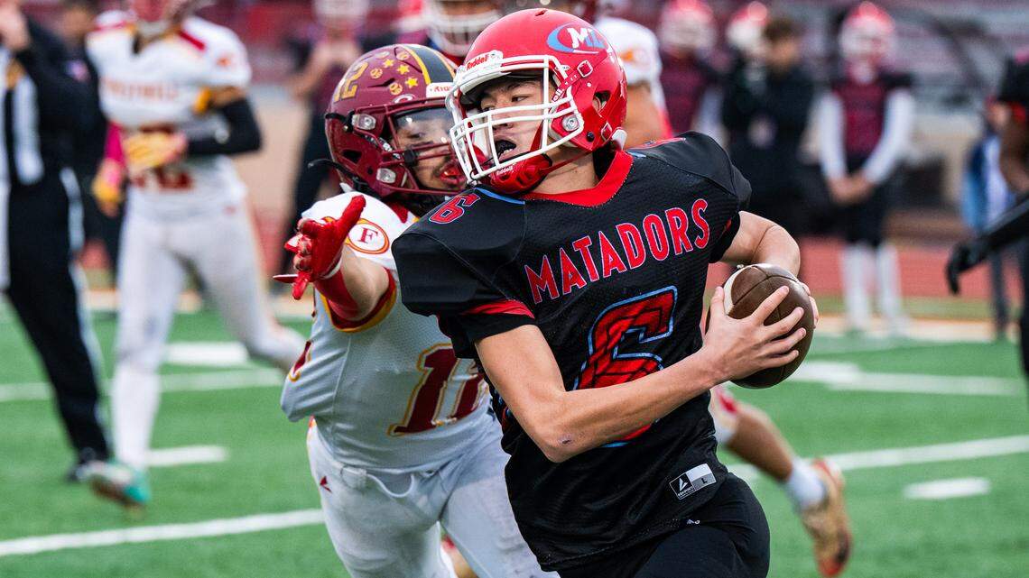 Mira Loma Matadors quarterback Deangelo Keys (6) escapes the grasp of Foresthill Wildfires cornerback David Silveria (12) on his way to a first down in the CIF Sac-Joaquin Section Division VIII championship at Hughes Stadium in Sacramento on Saturday.