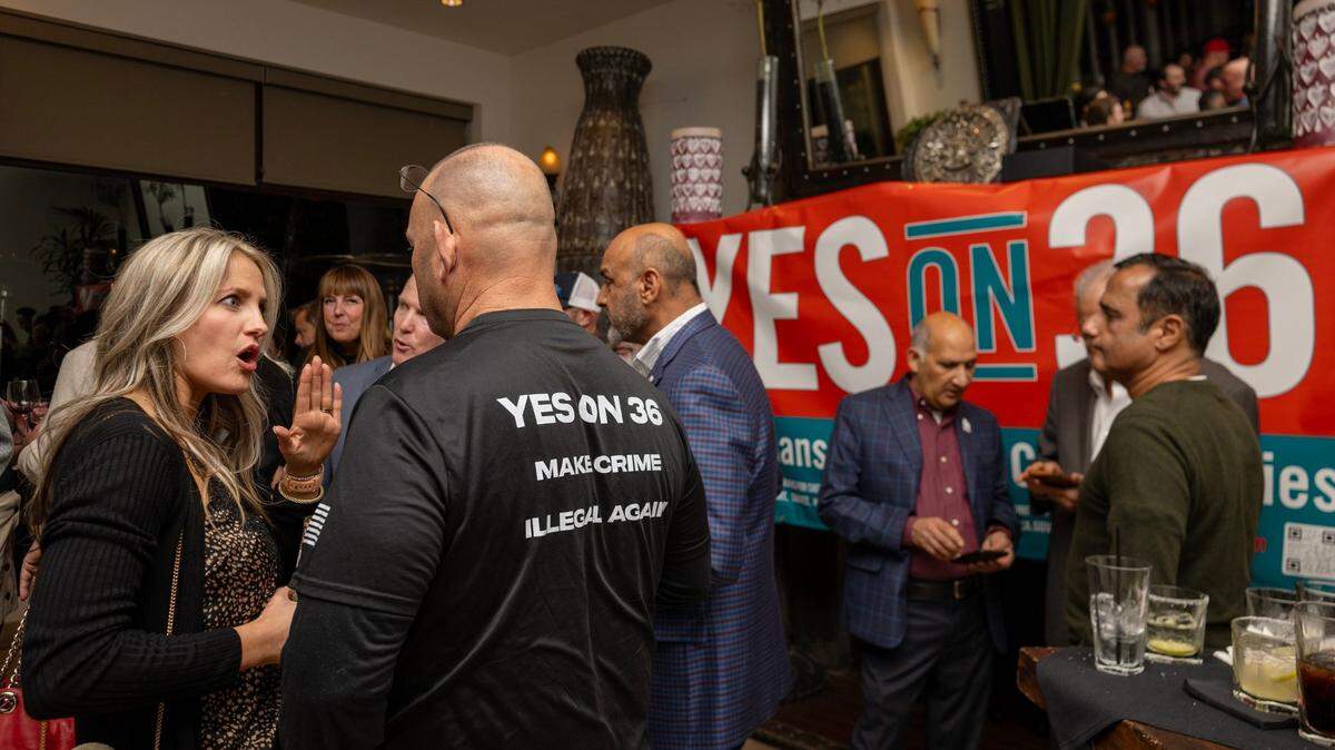 Proposition 36 supporters Abby Reisig, left, and Garrett Hamilton, wearing a “make crime illegal again” shirt, talk before results are announced during an Election Night party at Zócalo in midtown Sacramento on Tuesday, Nov. 5, 2024.