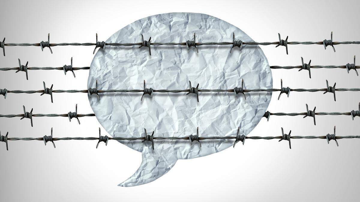 An illustration shows barbed wires crossing a cartoon speech bubble made out of crinkled paper