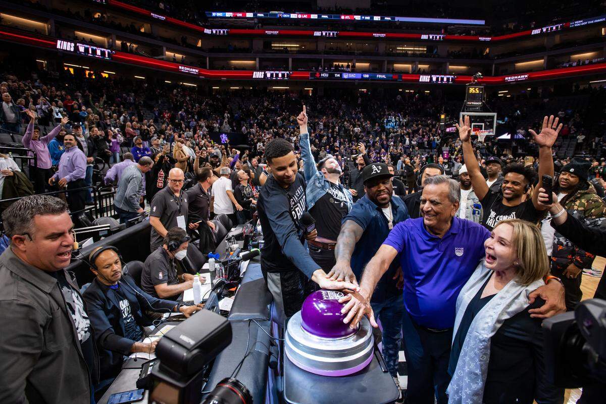 Sacramento Kings forward Keegan Murray (13), center, gets an assist from rapper and businessman 50 Cent to light the beam after the Kings’ blowout win over the Houston Rockets at the NBA basketball game Friday, Jan. 13, 2023, at Golden 1 Center in Sacramento. Kings personality Scott Freshour points to the monitor above, which shows the beam illuminating the sky above the arena.