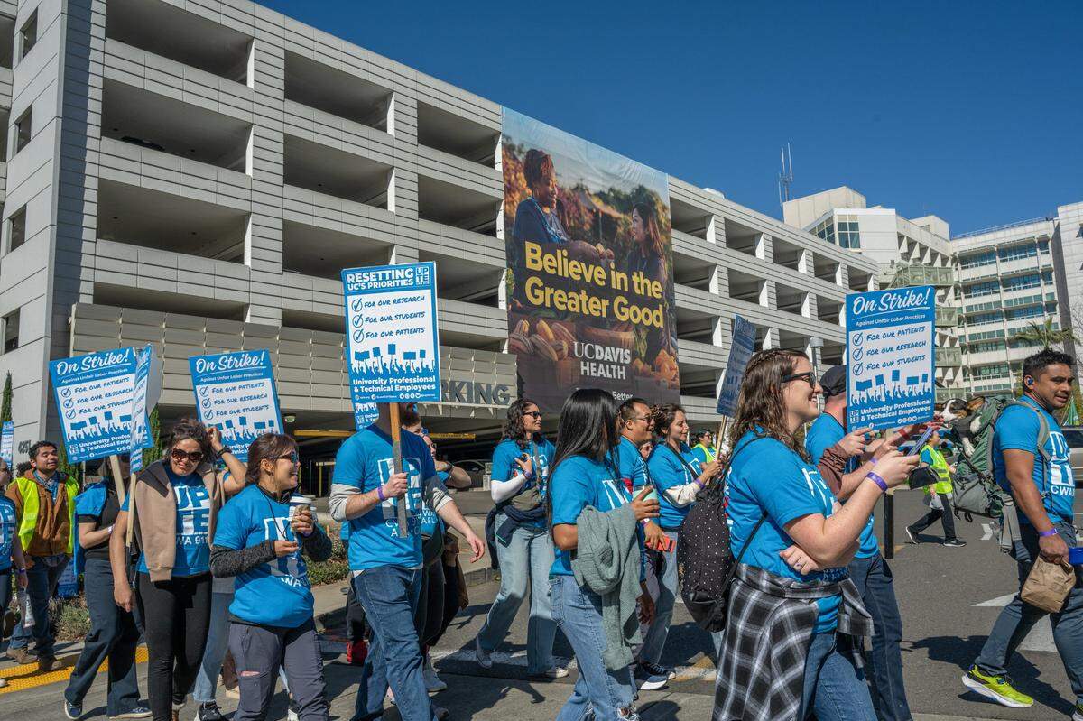 Picketers march toward a rally in front of UC Davis Medical Center in Sacramento on Wednesday. According to organizers, 4,000 health care, research and technical workers at the facility will be on strike through Friday over unfair labor practices and a staffing crisis.