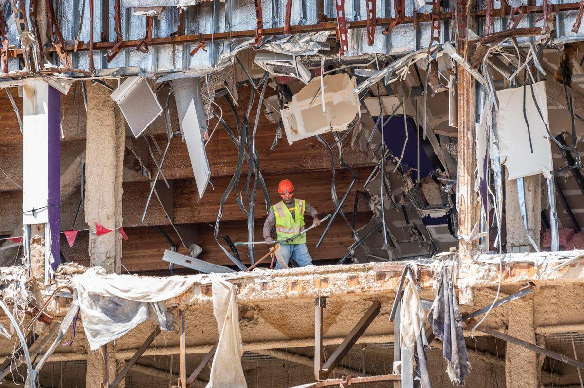 A construction worker moves debris out of Sleep Train Arena demolition on Tuesday in Natomas. A new hospital will be built at the site in Sacramento and also include over 3,000 units of housing, as well as retail space, bike trails and an amphitheater.
