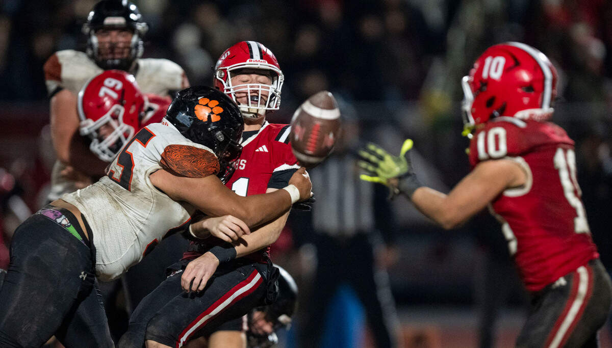 Winters the Warriors quarterback Lane Brown (11) takes a hit from Arcata Tigers’ Neiko Bryson (55) as he pitches the ball to Gio Jimenez (10) during the CIF Northern California Division 6-AA regional football championship game on Friday.