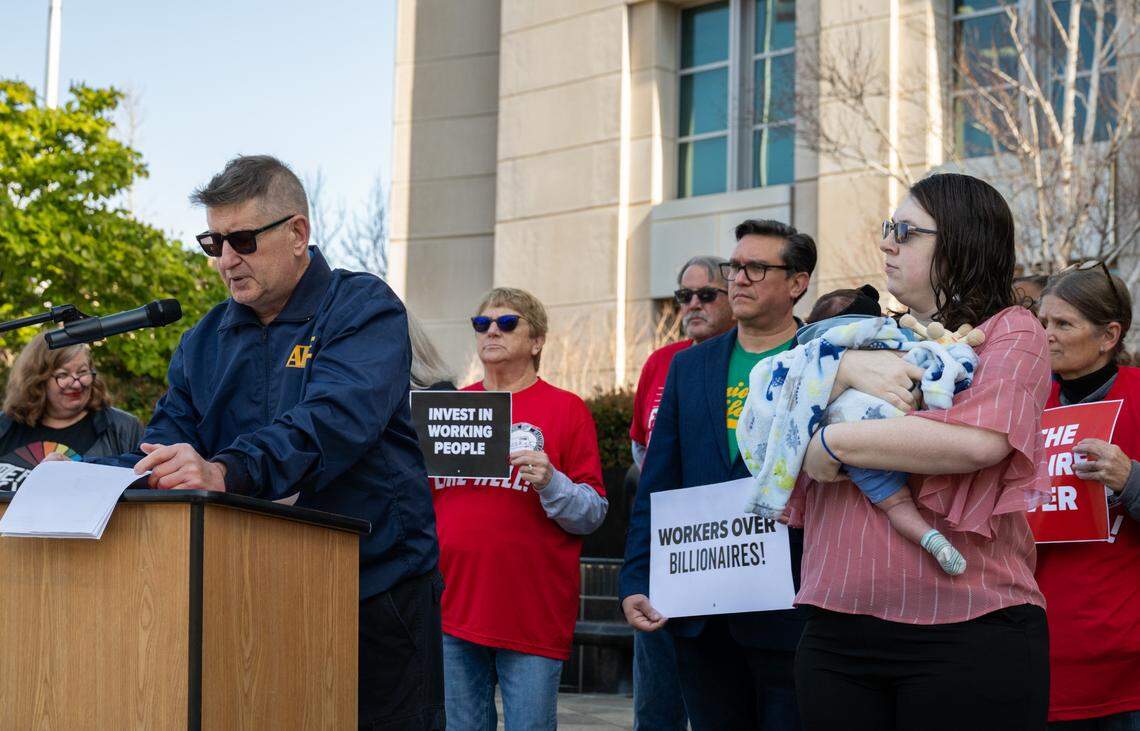 AFGE Local 1230 president James Mudrock, who represents Transportation Security Administration officers in California, speaks at a press conference in Sacramento on Tuesday about the Department of Homeland Security’s decision to revoke collective bargaining rights. Listening nearby is the TSA worker Mary Becker, currently on parental leave and holding her 7-week-old daughter Alice-Kingyo. Without the leave bargained by the union, Becker is worried she will have to return to work early.