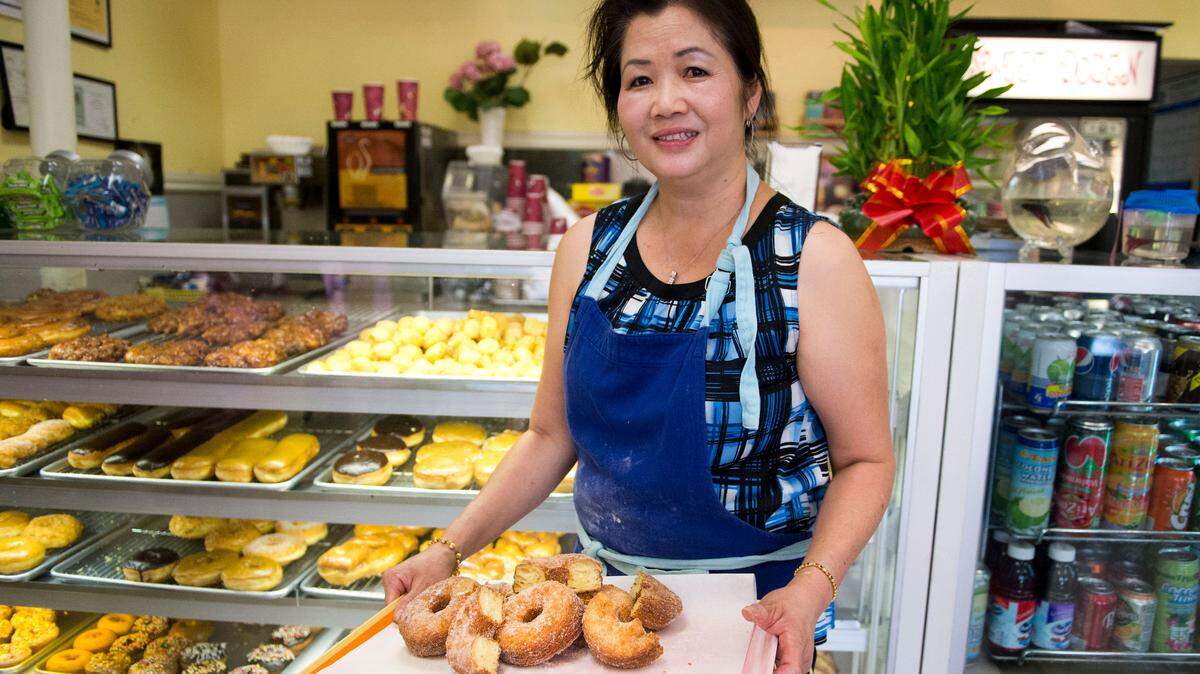Sengkeo Khamphay of Sweet Dozen holds some of the Cronut-like "Doissants" that she made at her shop on Thursday, August 22, 2013. Sweet Dozen reopened Wednesday.