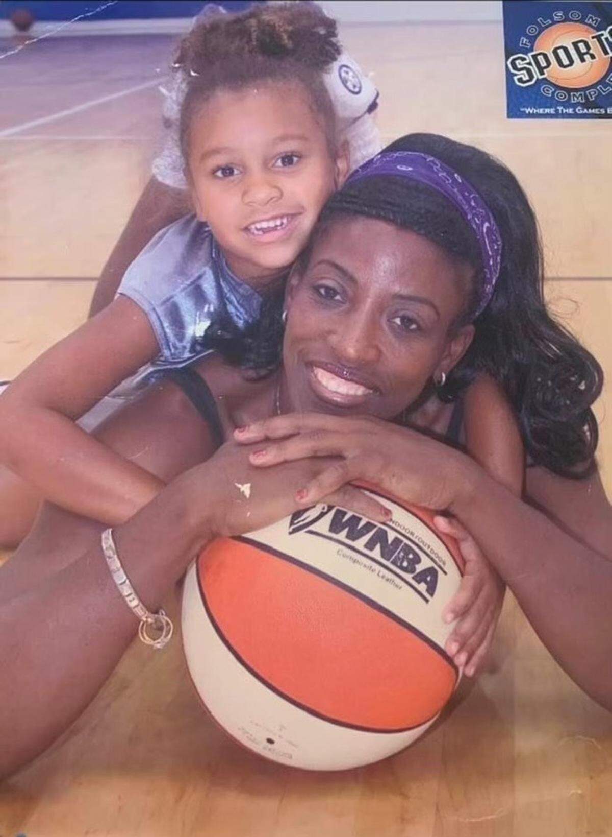 Three-year-old McKenzie Forbes hugs Sacramento Monarchs legend Ruthie Bolton.