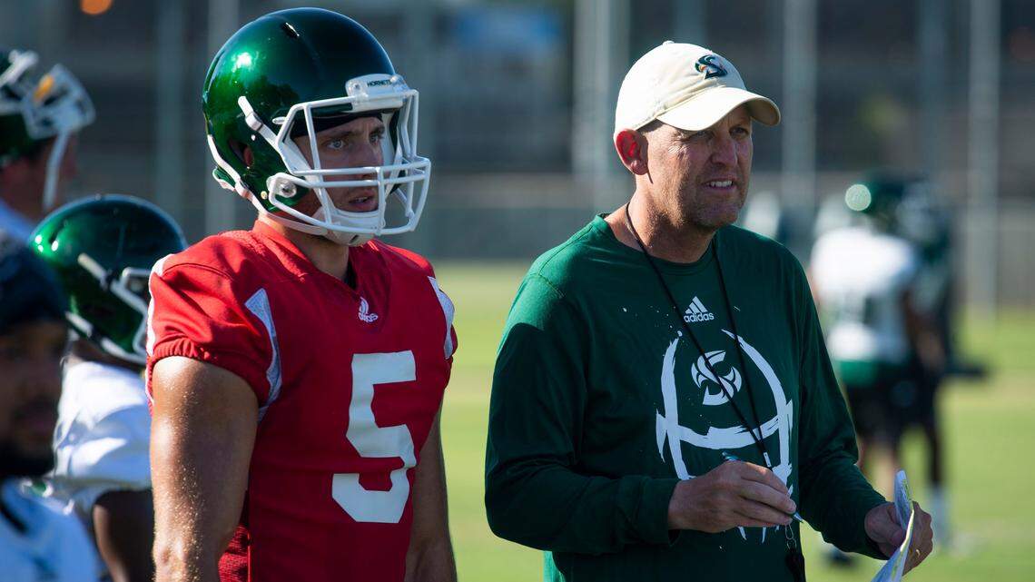Sacramento State’s head coach Troy Taylor speaks with Hornets quarterback Kevin Thomson during practice in 2019. The team lost Thomson to the University of Washington through the NCAA transfer portal last year.