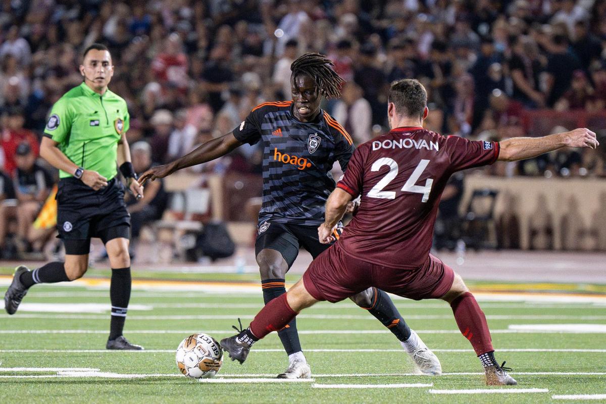 Sacramento Republic FC defender Conor Donovan (24) takes the ball away from Orange County SC forward Bryce Jamison (11) during the first half of the USL soccer game at Hughes Stadium on Saturday.. Republic FC returned to the site of its first match for a 10th-season celebration.