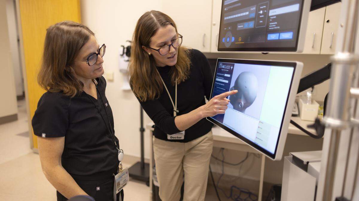 Dr. Debra Kahn, left, examines an image on a transcranial magnetic stimulation device with Dr. Katharine Marder at the Advanced Psychiatric Therapeutics Clinic at UC Davis Health on April 3, 2024. The Sacramento-based clinic is among several in the region expanding to address gaps in mental health care.