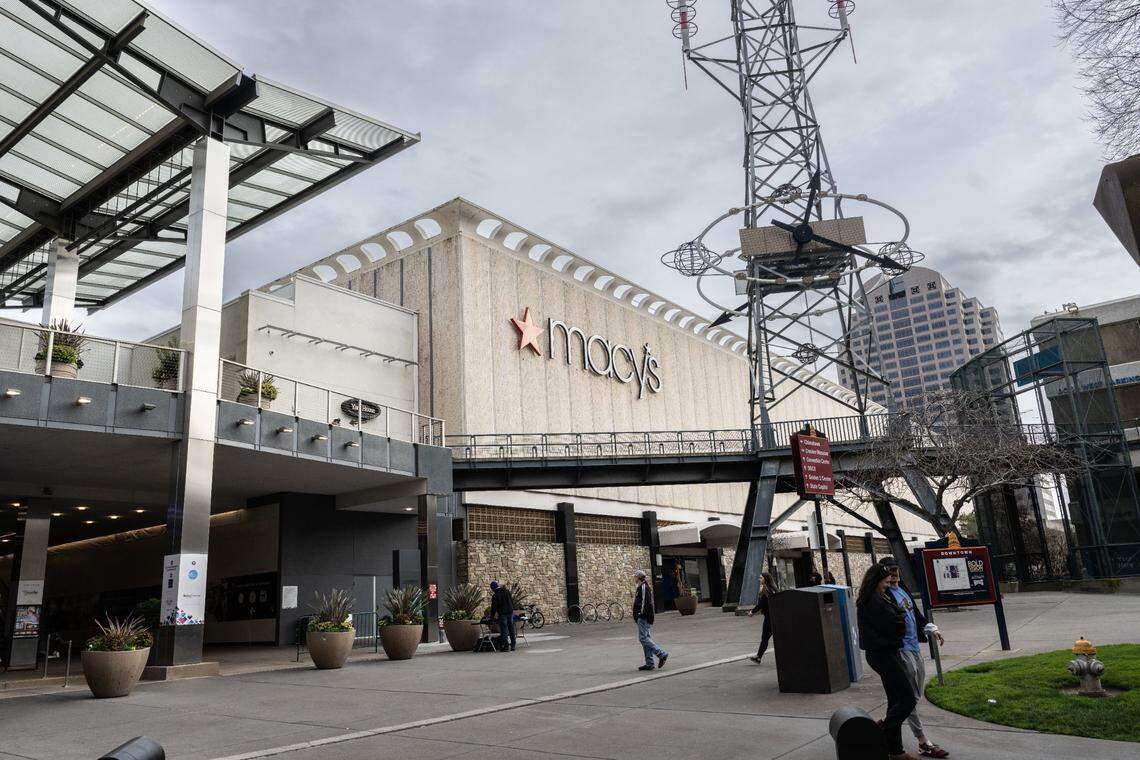 Pedestrians walk past the Downtown Commons Macy’s in March.