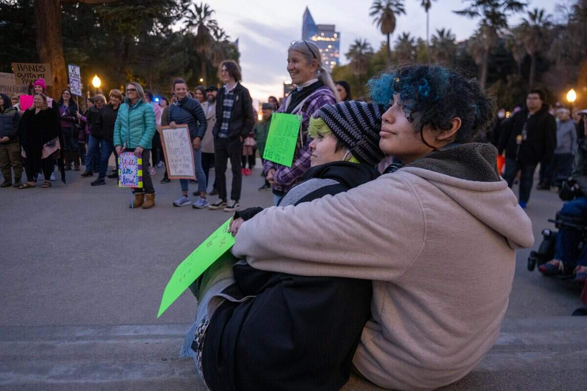 Max Rivera and Macy Ortega, right, of Sacramento listen to speakers at a transgender unity rally at the state Capitol on Thursday.