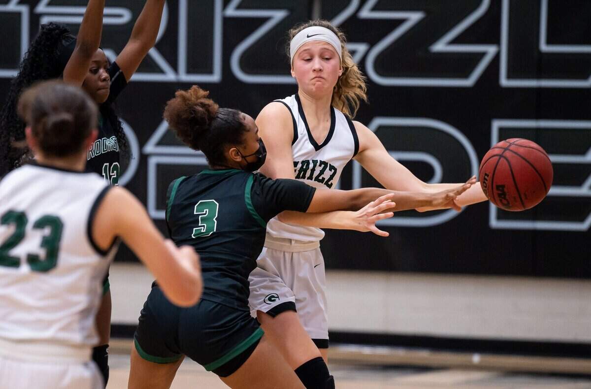 Granite Bay Grizzlies’ Julia Riley (33), right, passes around Rodriguez Mustangs’ Erica Burton (3), center, and Macie Gonzalez to teammate Riley Robertson (23) during the fourth period at the high school girls basketball Sac-Joaquin Section playoff game Thursday, Feb. 17, 2022, at Granite Bay High School. Rodriguez came from behind in the second half to beat Granite Bay, 57-50.