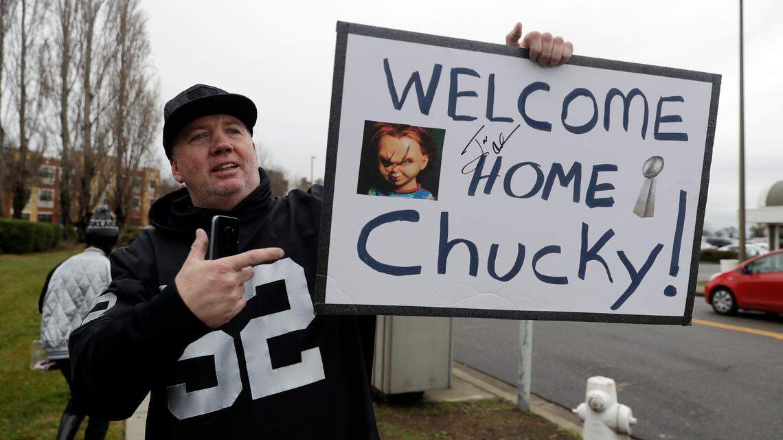 FILE -- Oakland Raiders fan Gary Nankivel holds a sign welcoming the team's new head coach John Gruden before an NFL football press conference to announce Gruden's hiring Tuesday, Jan. 9, 2018, in Alameda, Calif.