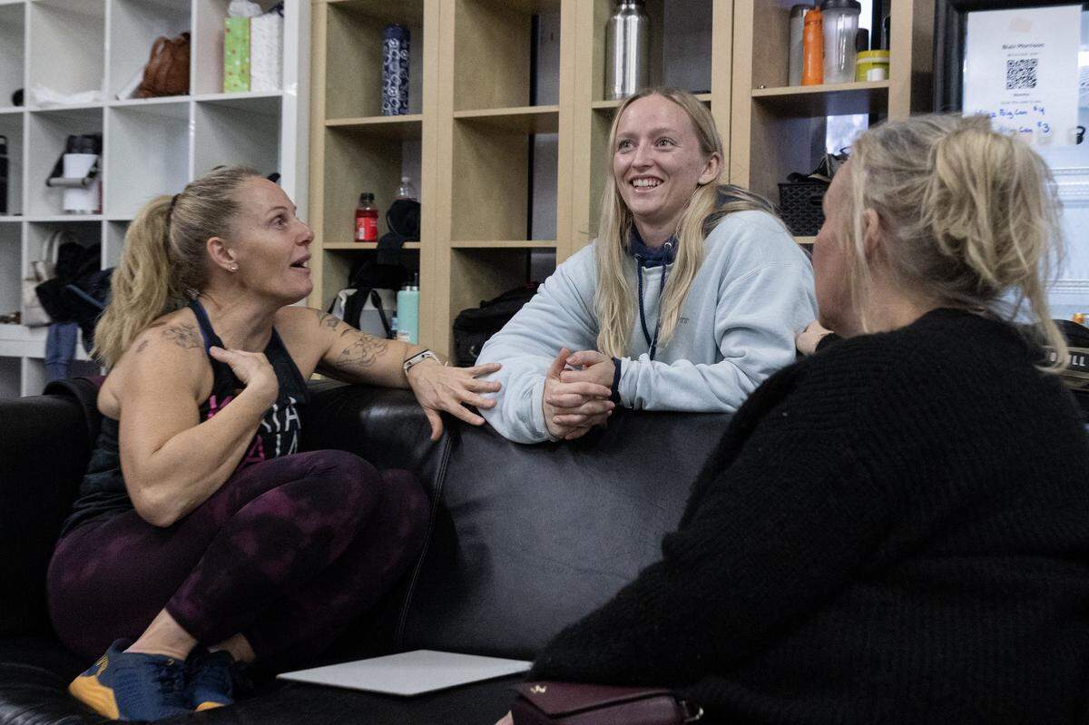 Michaela Mayer, center, talks with her friend Christina Rizzo and her mother Karen at AnywhereFit Folsom on Monday. Mayer, who was recently diagnosed with brain cancer, is a CrossFit coach, and her gym community is coming together for a fundraiser event in her support.