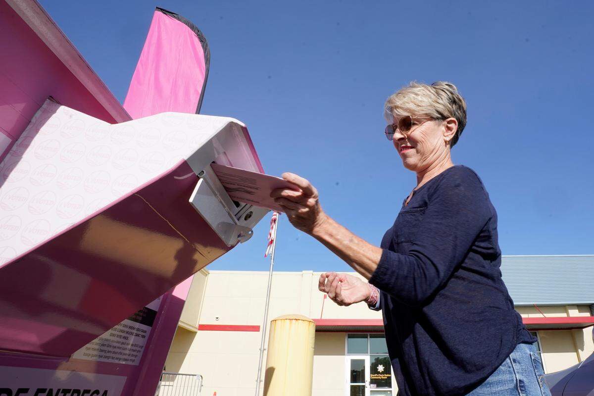 Susan Johnson casts her primary ballot at a drop-off box outside the Sacramento County Registrar of Voters office in Sacramento on Tuesday, June 7, 2022.