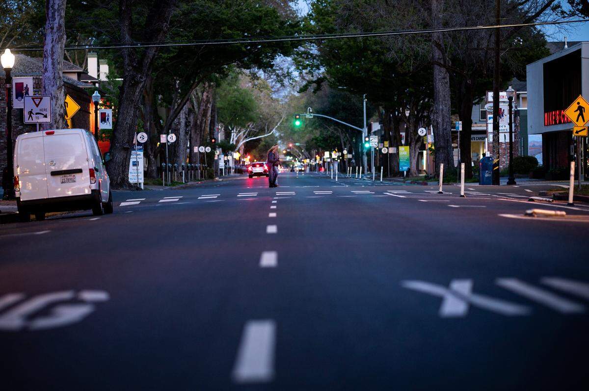 A couple crosses J Street on April 11, a rare sight compared to a month ago in midtown Sacramento.