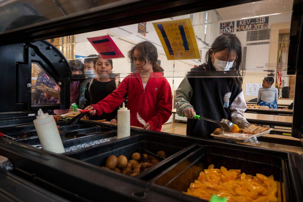 Escolares usan una barra de autoservicio para obtener su almuerzo en Oak Ridge Elementary en Oak Park la semana pasada. Muchas familias pasarían apuros sin comidas escolares gratuitas.