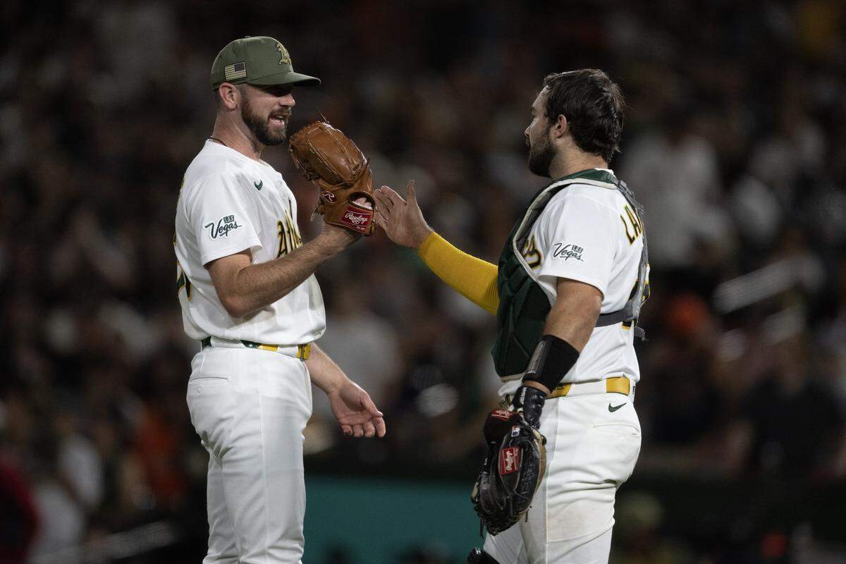 Athletics pitcher Hogan Harris, left, and catcher Shea Langeliers meet near the mound after getting the last out of a 5-2 win over the San Francisco Giants on Friday at Sutter Health Park in West Sacramento.