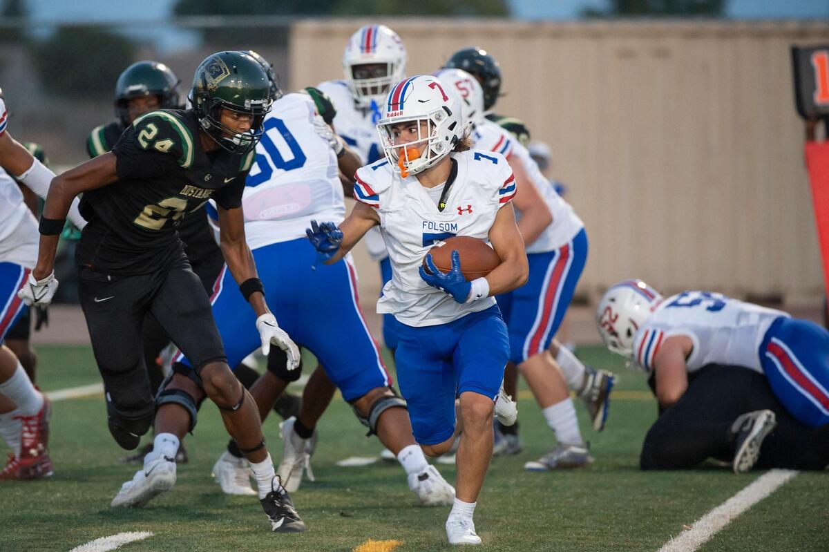 Folsom Bulldogs’ Daymion Rivera (7) runs the ball for a 4-yard touchdown in the first half of the opening night game on Friday, Aug. 18, 2023, at Monterey Trail High School in Elk Grove.