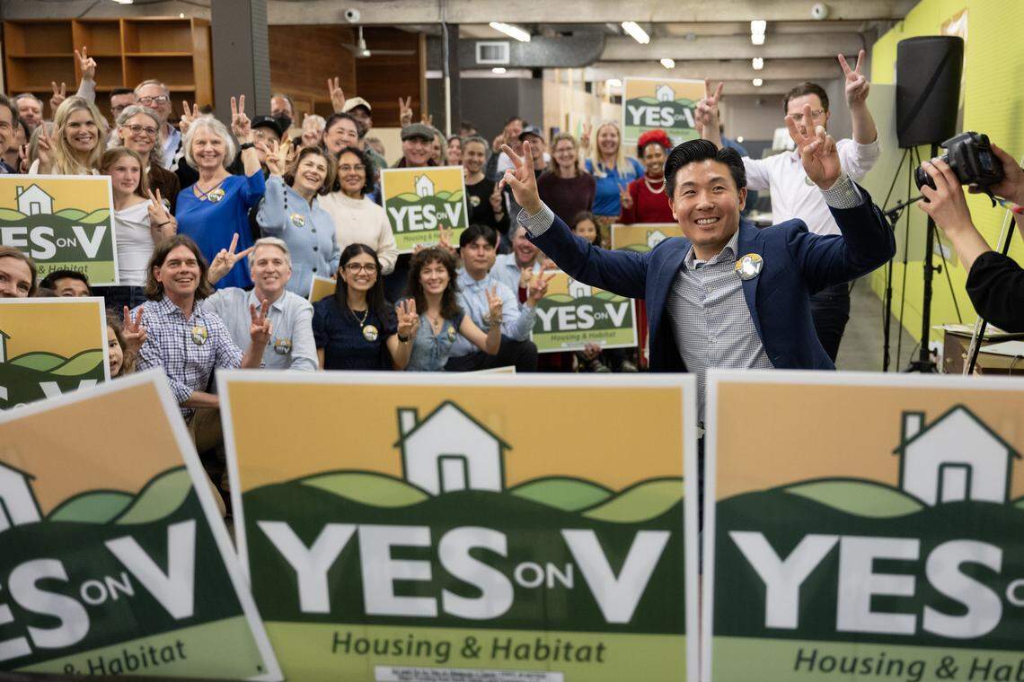 Campaign director Andrew Kim, right, and supporters of Yes on Measure V make the victory sign at the kick-off rally in Davis on Wednesday. The measure would allow a 498-acre development with 1,800 homes on the city's northern boundary to move forward.