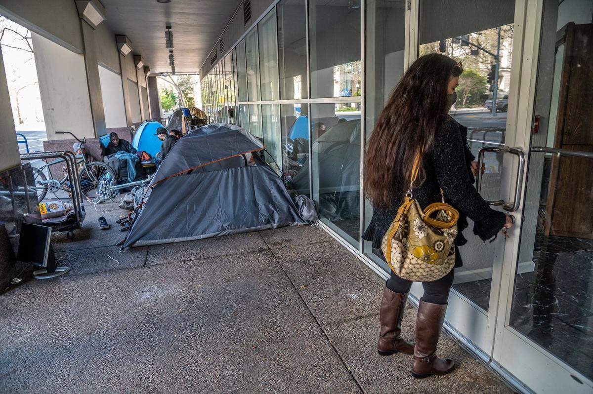 “This is the first time I can open the door without asking people to move,” says Alma Perez as she opened her salon for city inspectors to see the smoke damage inside in Sacramento on Wednesday, March 24, 2021. City Hall Garage, where the homeless had been permitted to park, was damaged by a fire caused by a van.