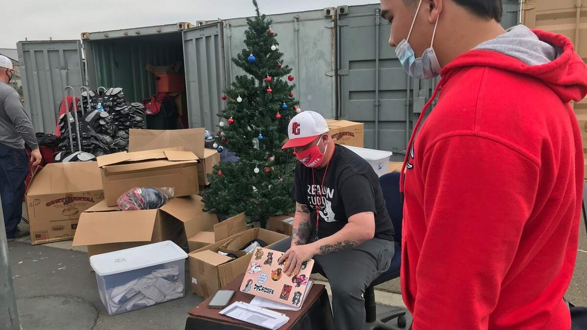 Pleasant Grove coach Matt Costa celebrates Christmas in March by handing out gear to his football players.
