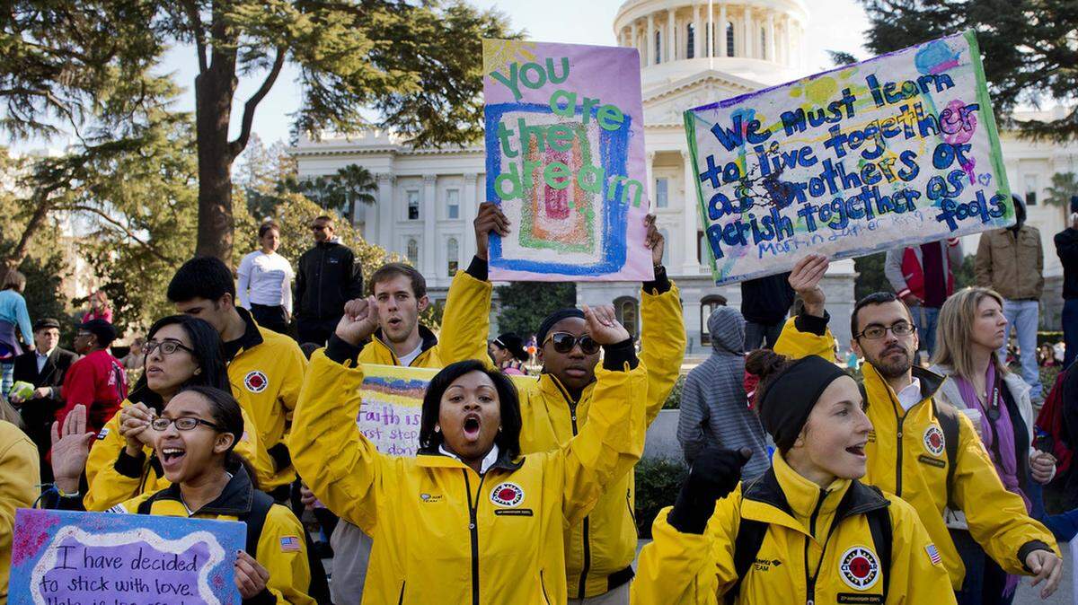 Briana Osbourne, 23, left, Kelly Besmer, 21, center, and Kelly Besmer, 21, right, all of Sacramento cheer on marchers in front of the California State Capitol at the 33rd Annual Capitol March for the Dream to commemorate Martin Luther King, Jr. on Monday January 20, 2014 in Sacramento, Calif. They were with City Year an educational based Americorps program.
