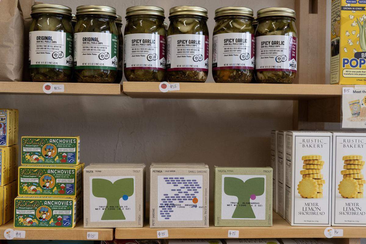 Real Mojo Foods’ Hot-n-Zesty pickles are on sale alongside other locally produced items, marked with red tomato stickers, at Superette in Sacramento on Monday, Dec. 1, 2025.