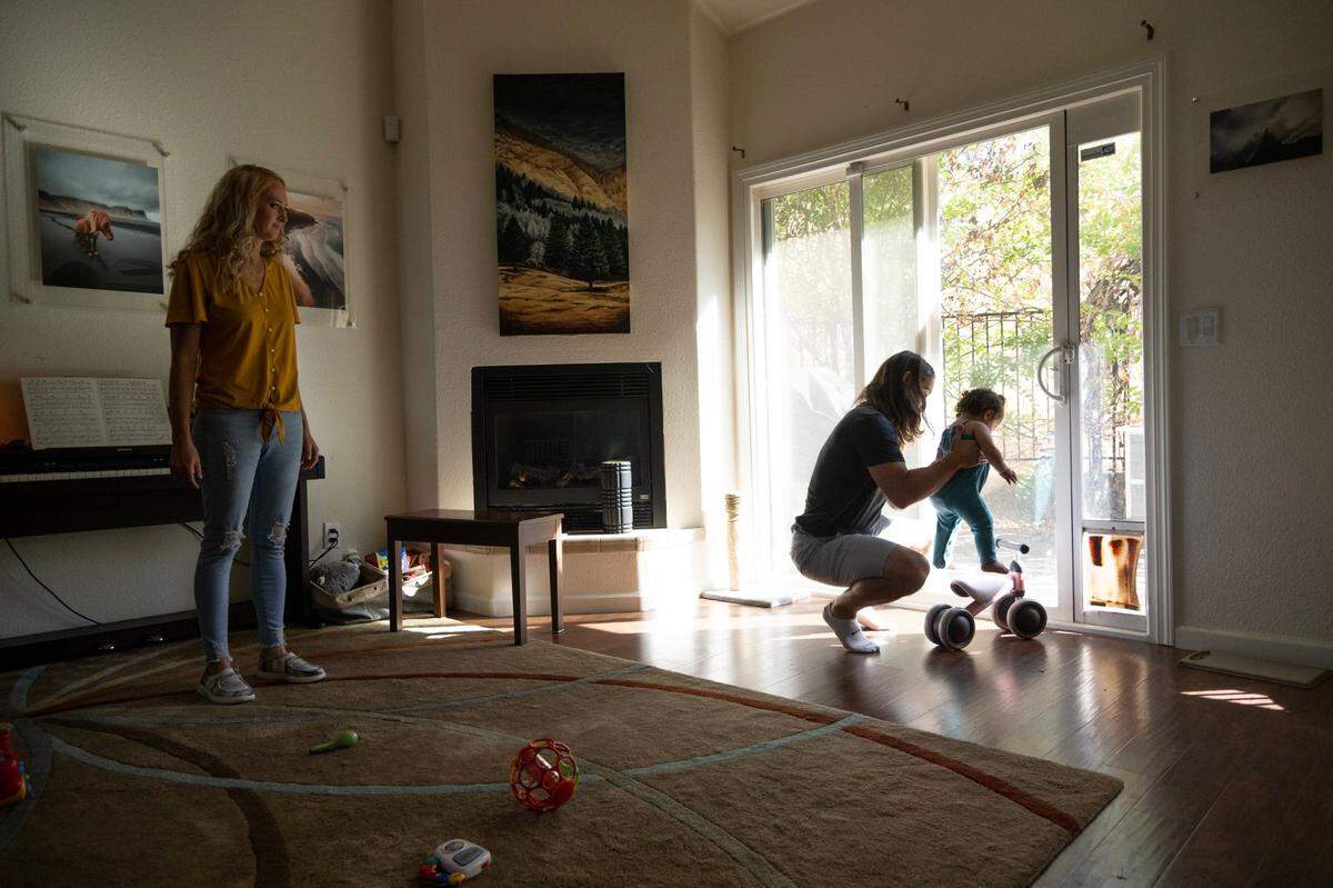 Adam Ingwell holds adopted daughter, Sawyer, at home in Copperopolis in August while his wife Jill watches.