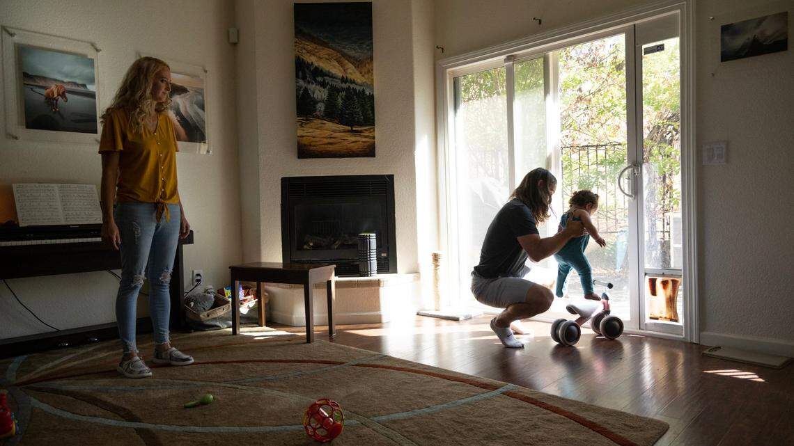 Adam Ingwell holds adopted daughter, Sawyer, at home in Copperopolis, Monday, Aug. 22, 2022, while his wife Jill watches. 