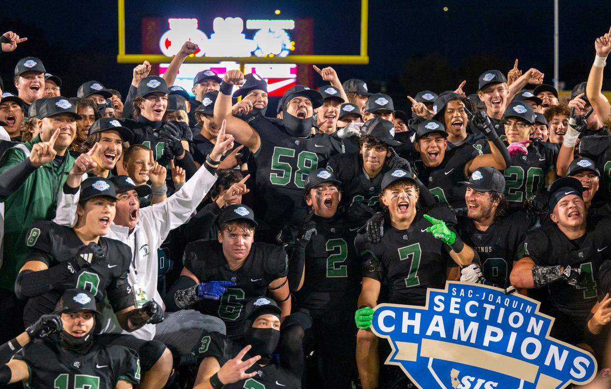 Twelve Bridges Raging Rhinos coach Chris Bean, left, and his team celebrate defeating the Patterson Tigers 55-7 for the Sac-Joaquin Section Division IV championship on Friday at Hughes Stadium in Sacramento.