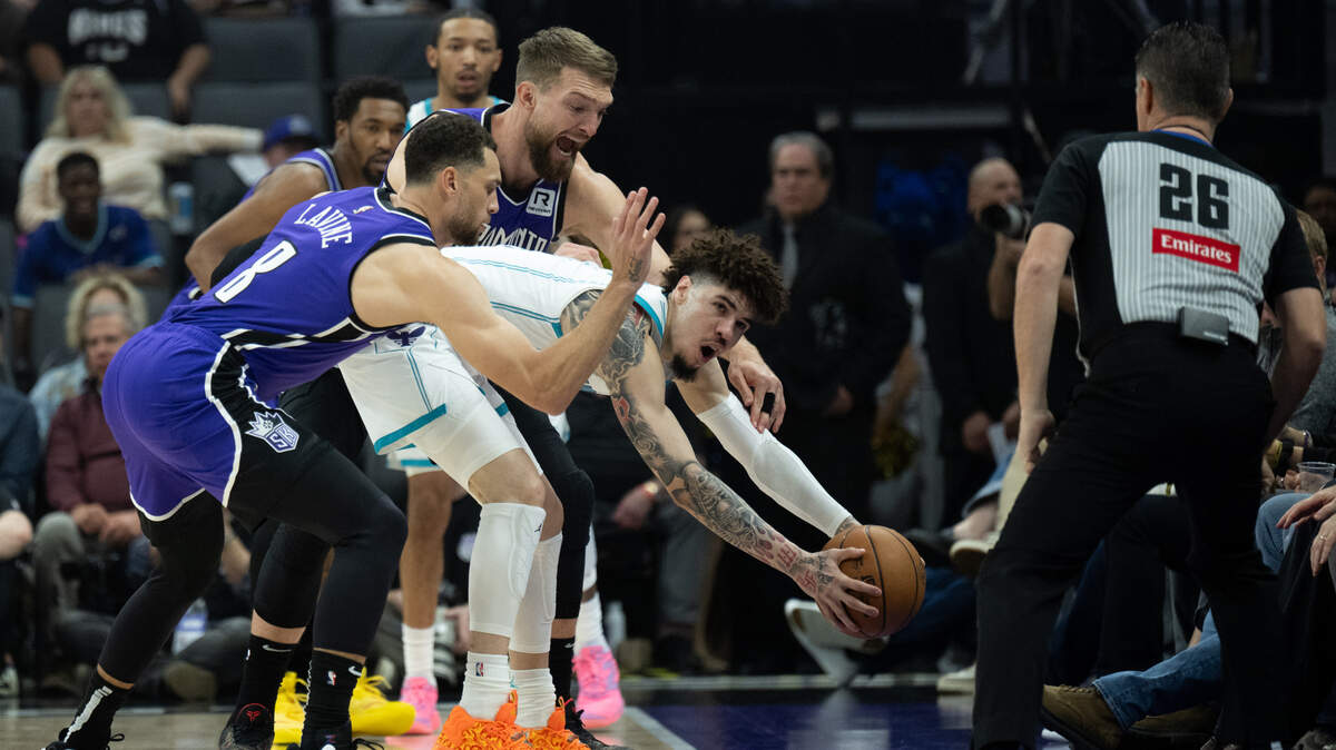Sacramento Kings center Domantas Sabonis (11) and guard Zach LaVine (8) trap Charlotte Hornets guard LaMelo Ball (1) at Golden 1 Center on Monday.