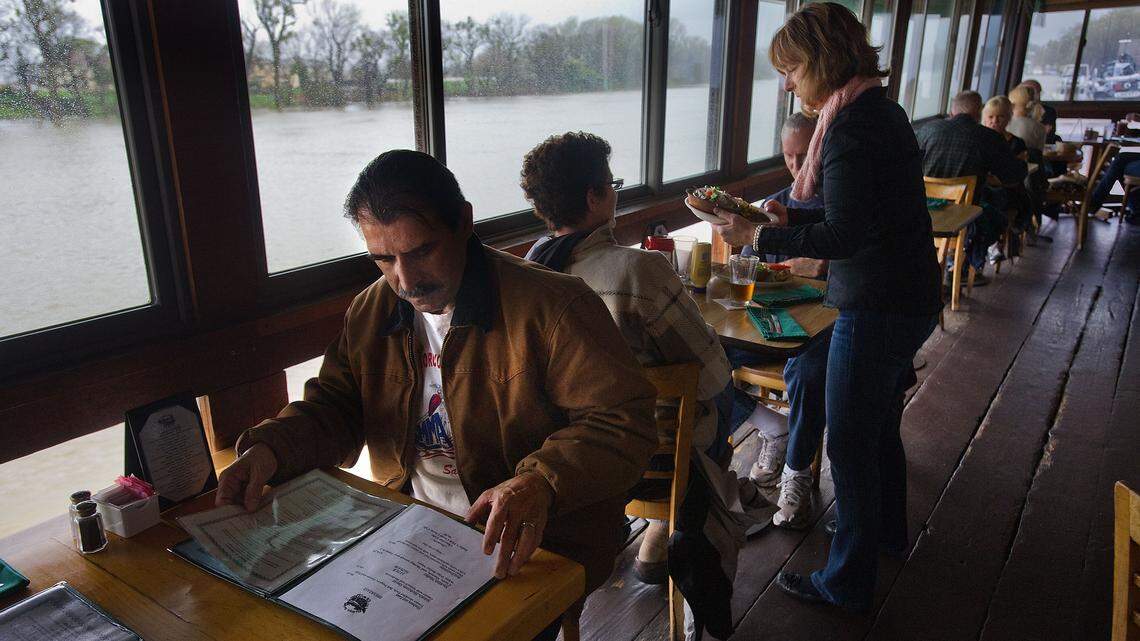 Herb Breisacher sits above the high water and peruses the menu at The Virgin Sturgeon restaurant.