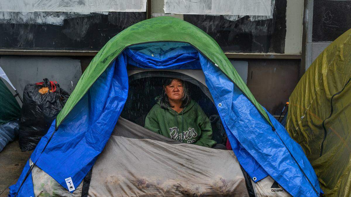 Mane “Jessica” Davila stares out of her tent on a rainy day on 10th Street in Sacramento on Wednesday, Nov. 5, 2025. The association representing California’s counties is suggesting a formalized partnership between state and local governments to address homelessness.